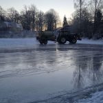 Traktor med vattenspridare spolar isbanan en sista gång.